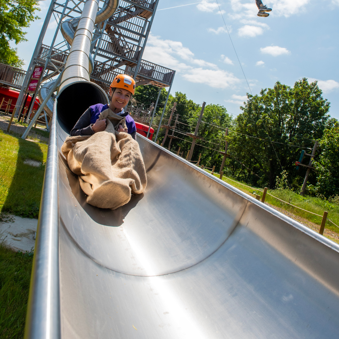 Child racing down the Speed Slides at Gripped London during a Sky Nets Adventure Party