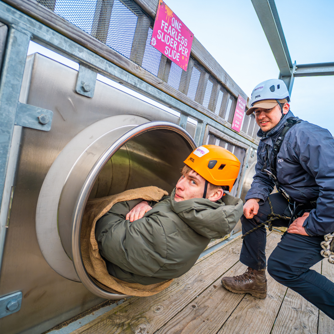 Young adventurer getting ready to slide down the Speed Slide at Gripped London during a birthday party adventure.